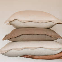 Load image into Gallery viewer, three stacked linen pillows on hands