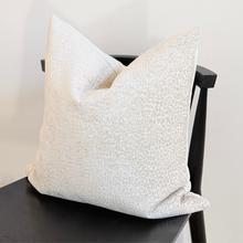 Load image into Gallery viewer, Textured white pillow on a black chair against a white background