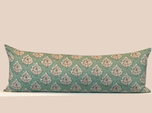 Load image into Gallery viewer, A long rectangular lumbar pillow with a green floral pattern on a beige background, featuring a natural canvas backing with a hidden zipper and a vegan leather logo tag.