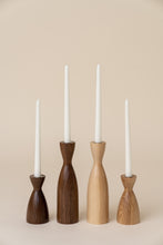 Load image into Gallery viewer, four candle holders holding white candles on tan background