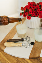 Load image into Gallery viewer, bottle openers with wood handles and red flowers in background 

